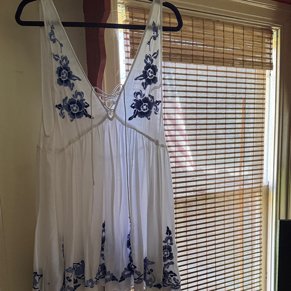 Free People. Size medium. No staining. White Dress with Blue Floral Embroidery.